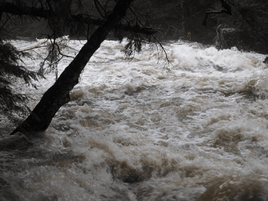 photo of flowing river water in flood stage